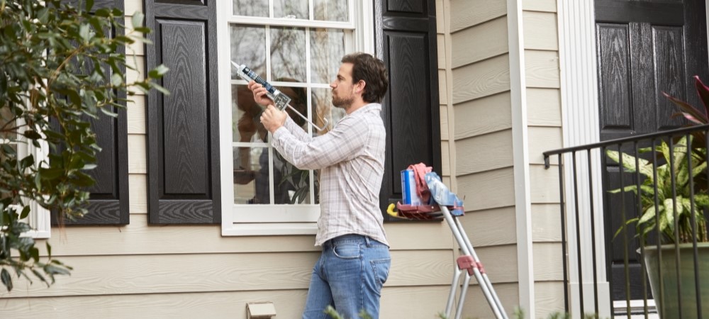 A person seals their home.